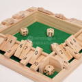 Close up on wooden dice on a green felt base of the Montessori Number Knockdown game.