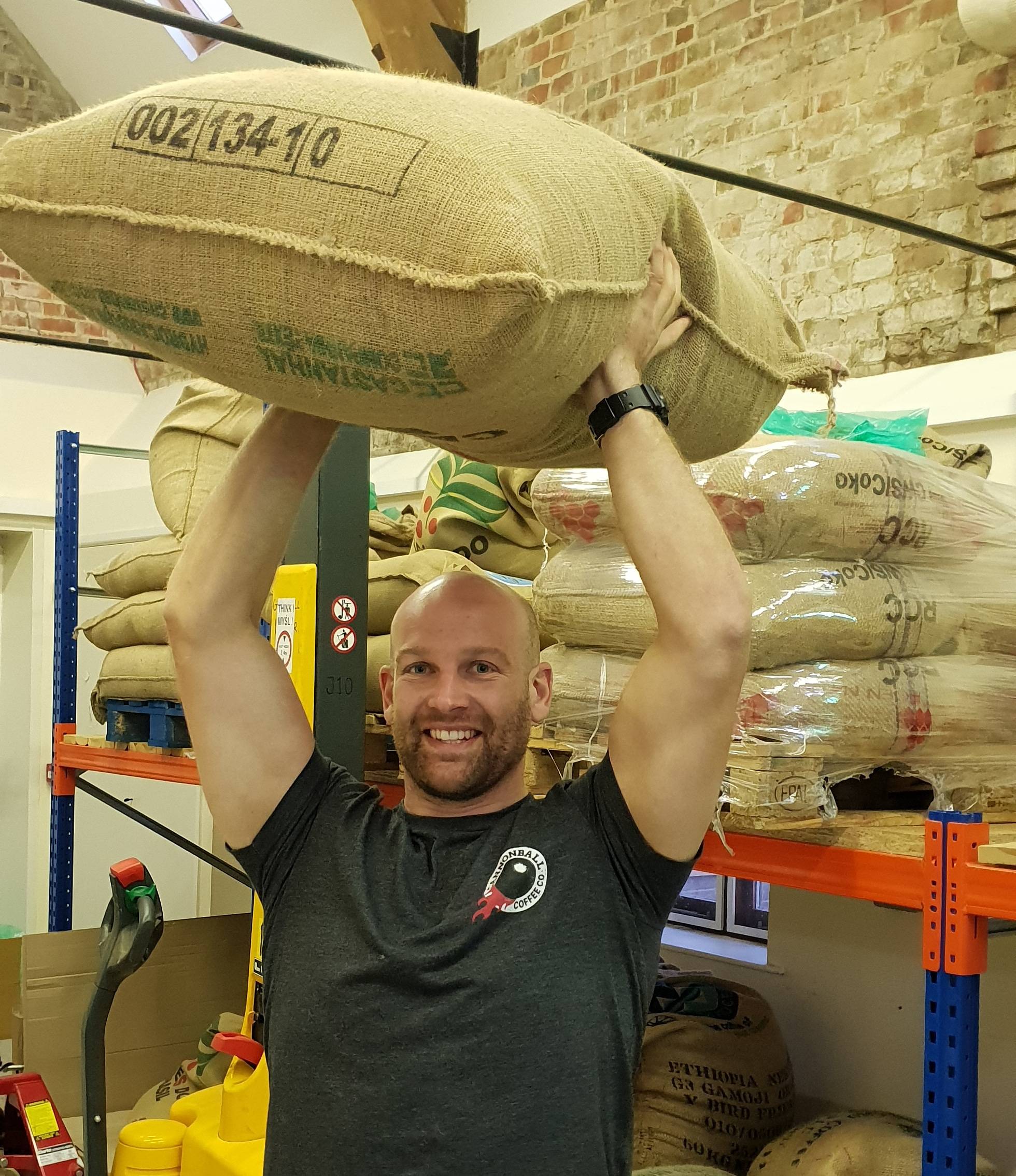 founder of cannonball coffee holding a bag of green coffee beans