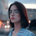 Portrait photo of a redhead lady with glasses.