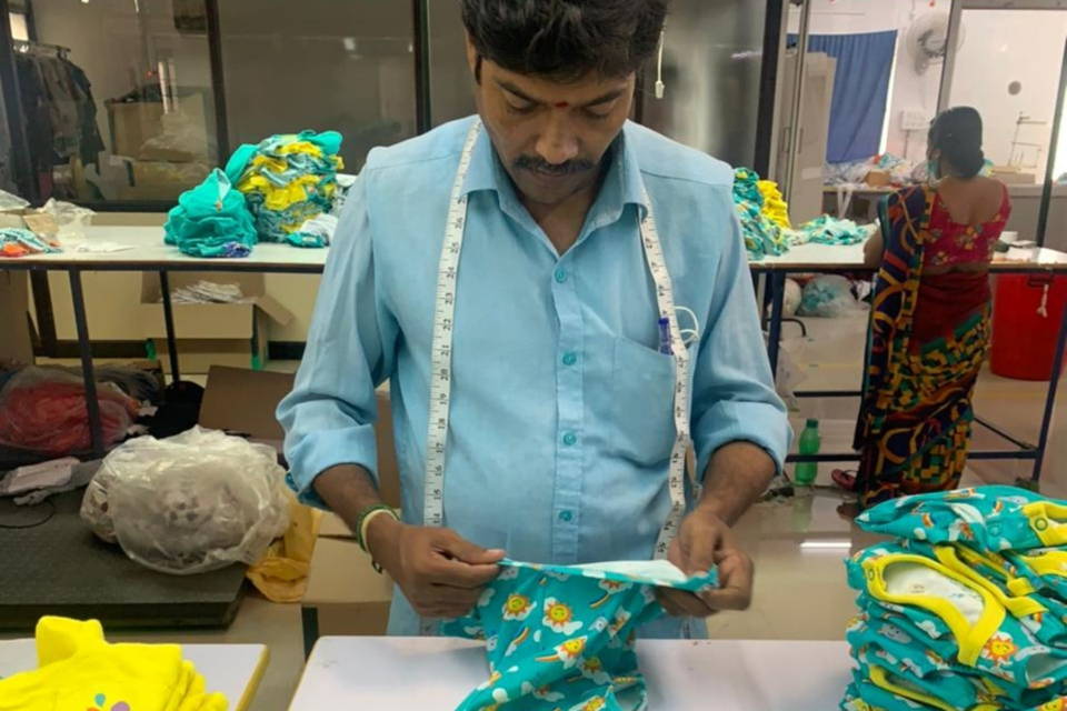 Image of a man called Guna carefully checking the quality of the Ducky Zebra clothes