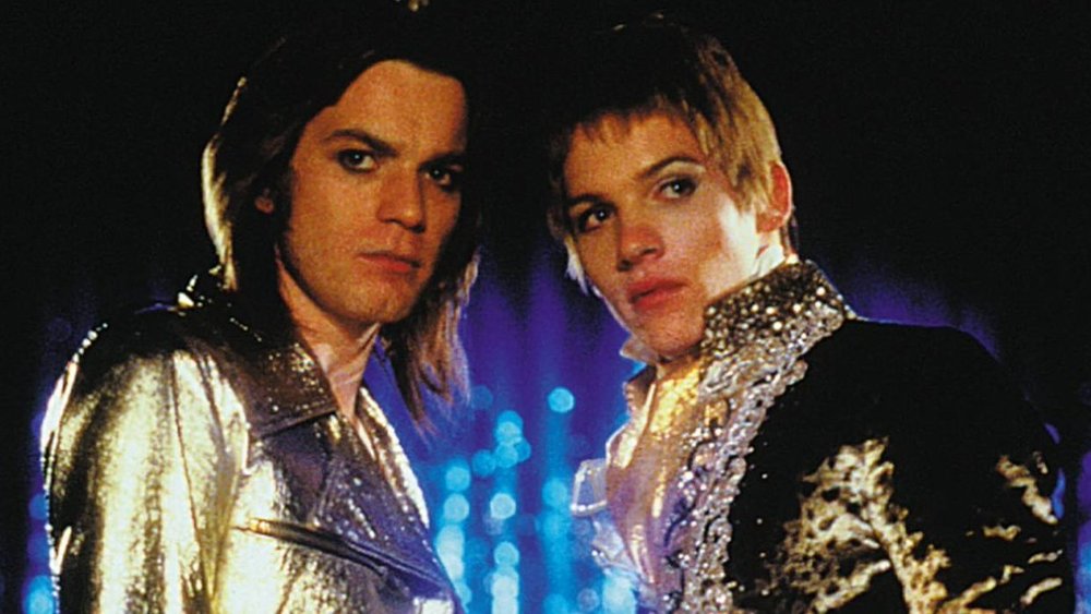 Brian and Kurt standing side by side wearing elaborate costumes for performing. Looking at someone off camera.