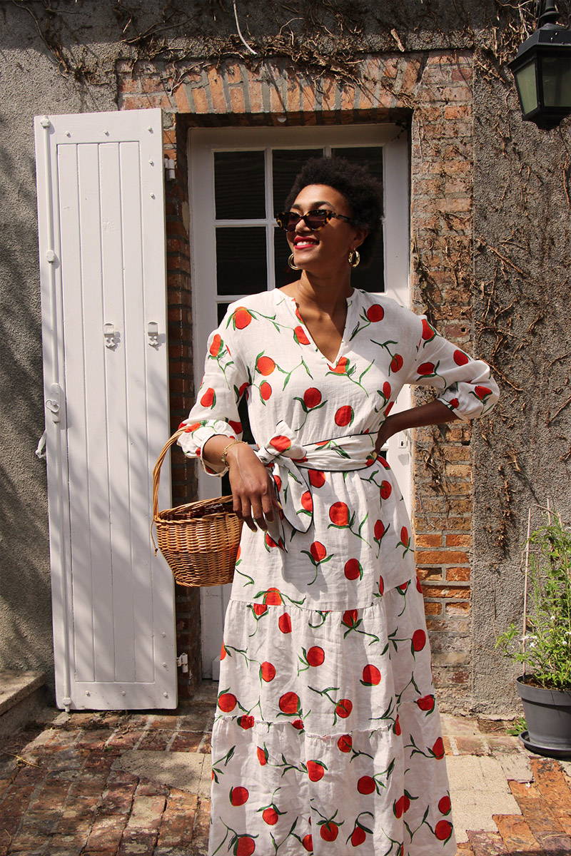 Lena Farl wears YOLKE Orange Linen Babushka Dress in front of a French cottage