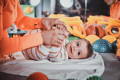Parent gently holding baby’s feet during playtime on a soft mat