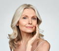 middle-aged woman with graying hair and smooth, radiant skin with use of hyaluronic acid