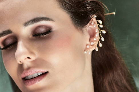 Close up view of lady wearing the VINI ear cuff with peach freshwater rice pearls.