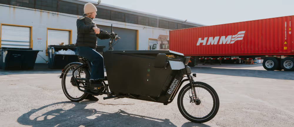 Rider on Urban Arrow electric cargo bike in parking lot
