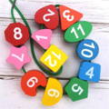 Wooden pieces of the Montessori Penguin's Clock children's toy with vibrant paint and numbers on them. 