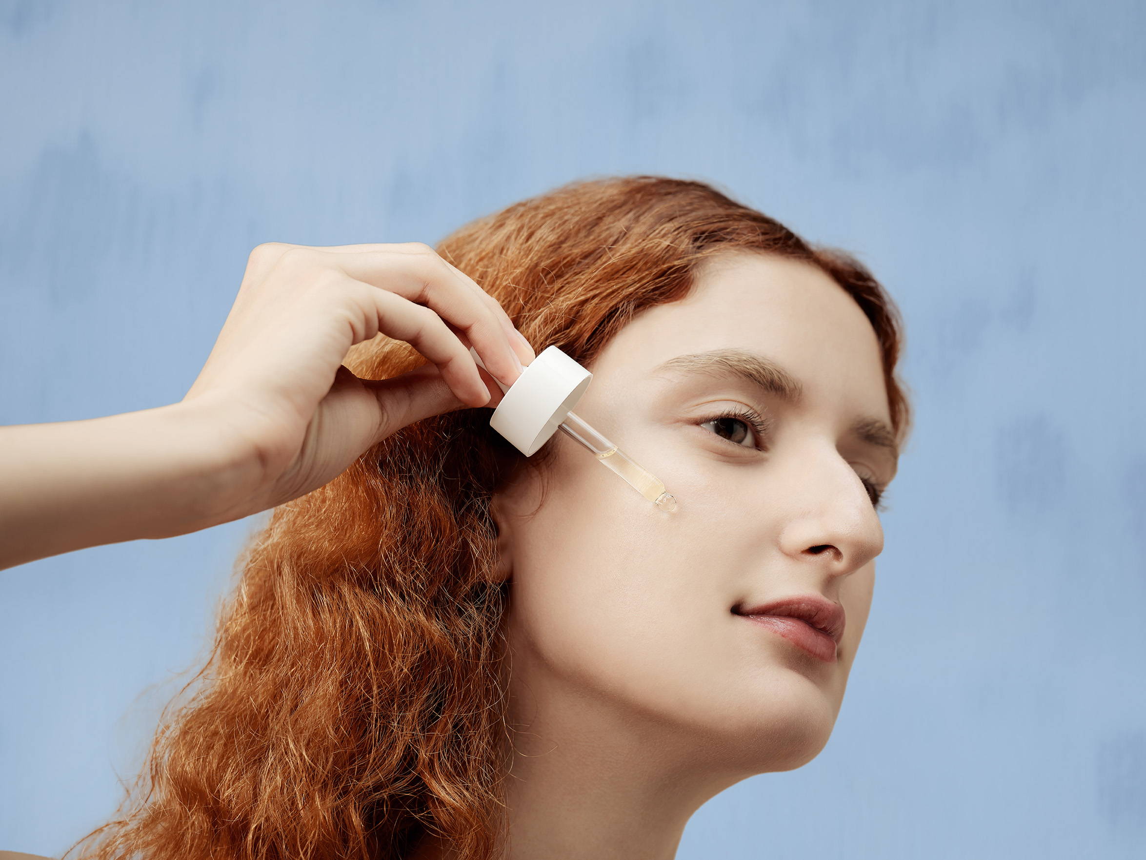 woman applying serum on her face