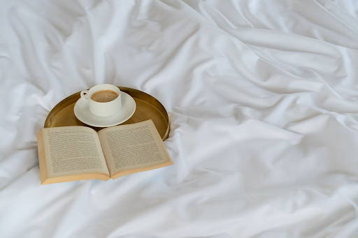Featuring Weavve's Lyocell sheets in Cloud White, with a coffee mug and book on top of it