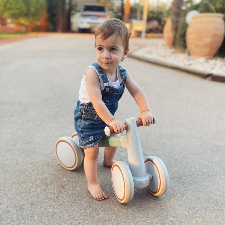 Little girl sitting on her baby bike.
