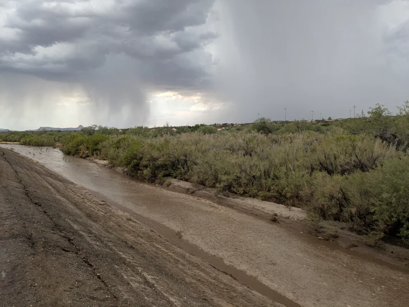 Arizona monsoon storm falling in a large desert wash