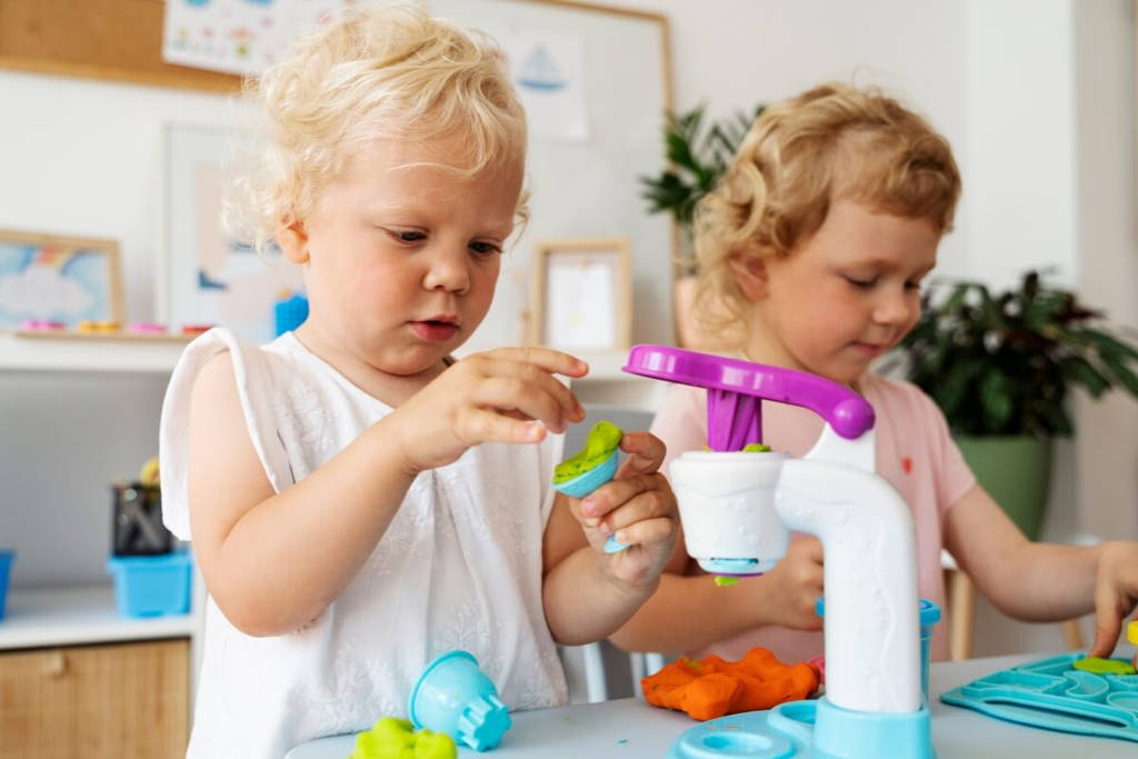 Sisters playing  with make dough.