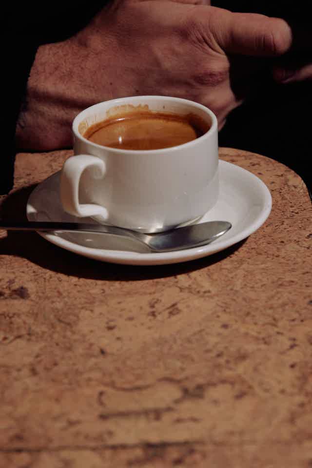 Espresso served on a saucer and spoon on a table 
