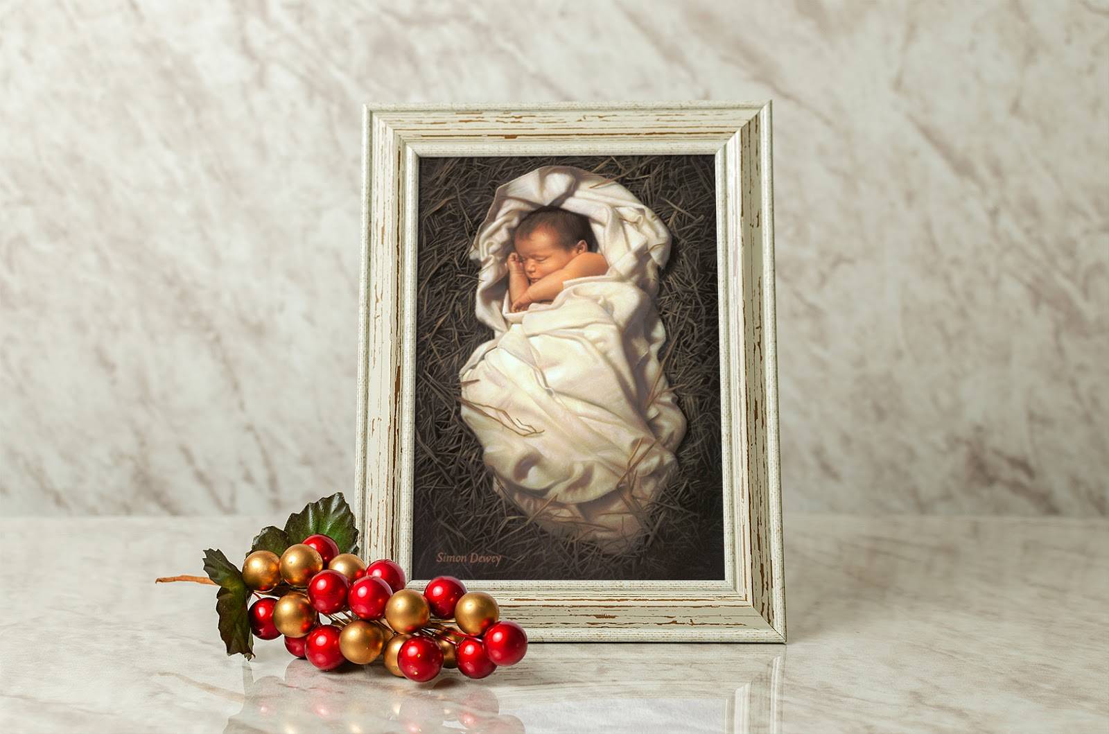 Small art of baby Jesus sleeping on straw. It is placed next to a simple Christmas accent piece. 