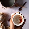 A white mortar and pestle filled with reddish orange ground saffron