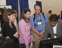 Sam Vassa of Figlo gives a demo to Laura Seymour of TorchLight Advisors and Johannes Fure of Fure Financial. Woman on far left as yet unidentified!