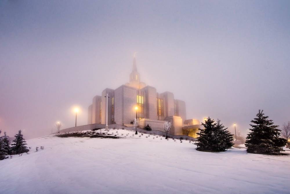 Calgary Temple lights glowing amid snow and fog. 