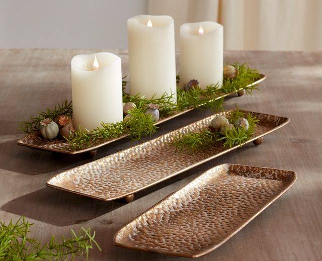 low hammered gold trays with greenery and pillar candles