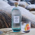 Bouteille de Gin Isle of Harris Gin et verre de cocktail posés sur le sable près de la distillerie Isle of Harris sur l'île de Harris dans les Hébrides extérieures d'Ecosse