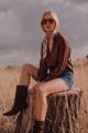 Model in a brown button-up blouse, printed neck scarf and denim shorts - Everyday Tops