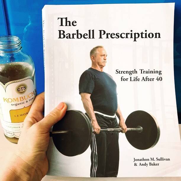 the barbell prescription strength training book in hand