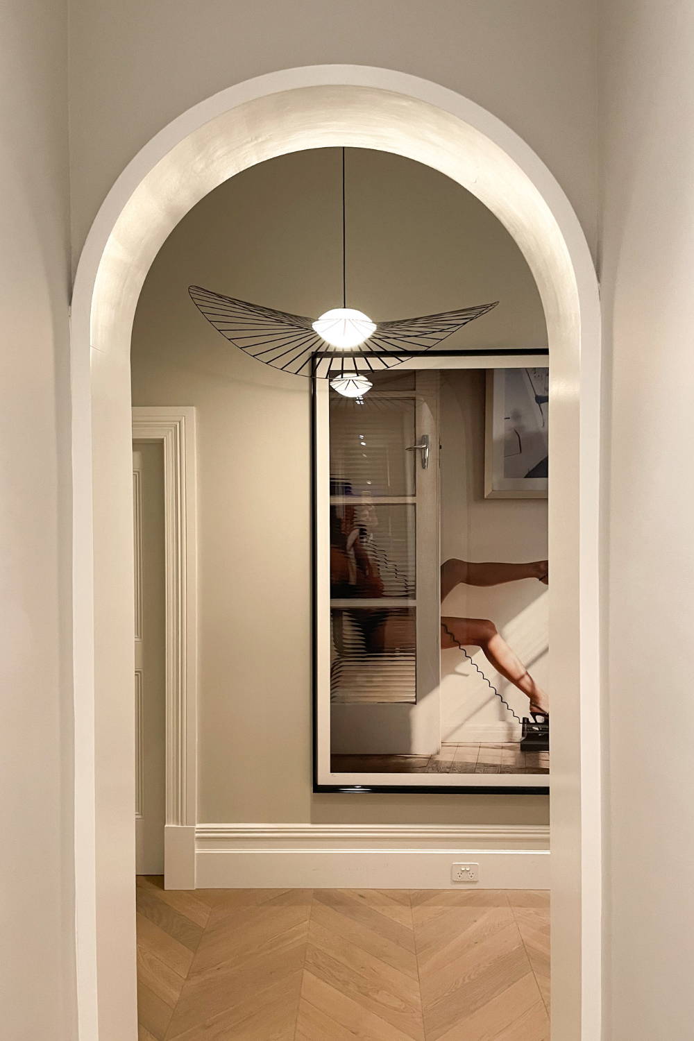 'Call Out' by Dina Broadhurst - A photographic print of a girl on the phone with stiletto heels in the air, captured in an entrance space.