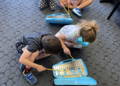 A group of young children holding stringed instruments participating in a group music lesson with their instructor. 