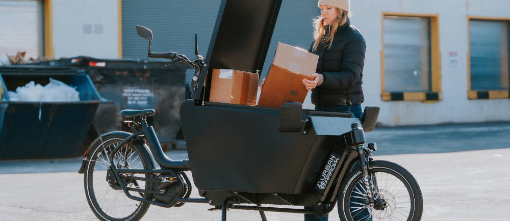 Woman loading boxes into Urban Arrow electric cargo bike