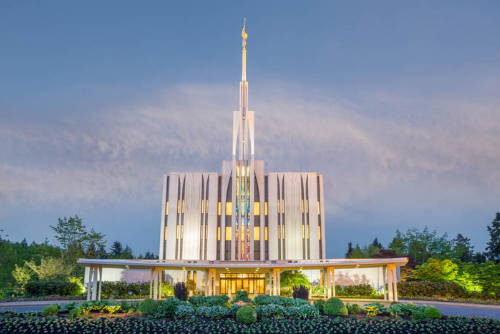The Seattle LDS Temple glows against a blue sky.