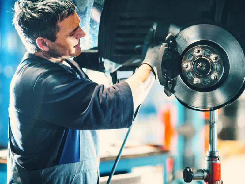 Mechanic Using a Brake Bleeder Pump