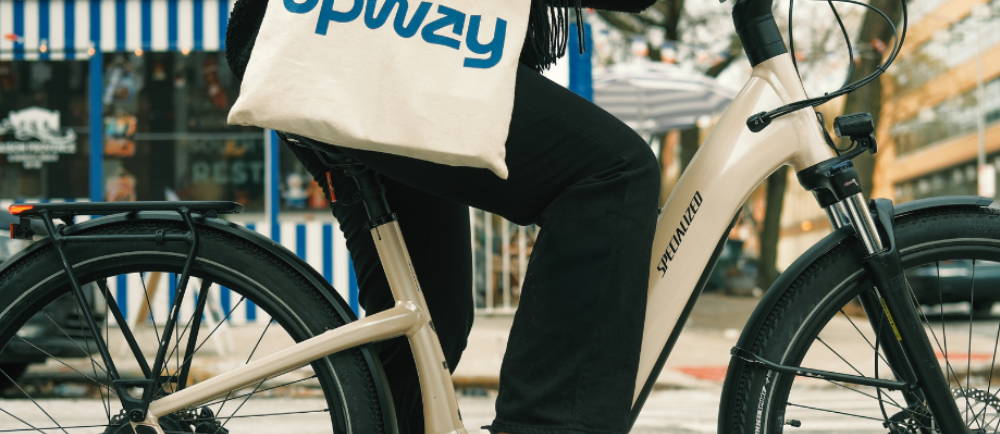 a woman carrying an Upway bag riding a Specialized electric city bike