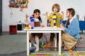 Montessori teacher and students in a playroom.