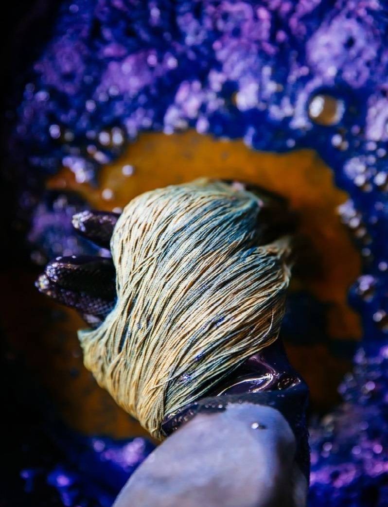 hand holding indigo dye for linen thread