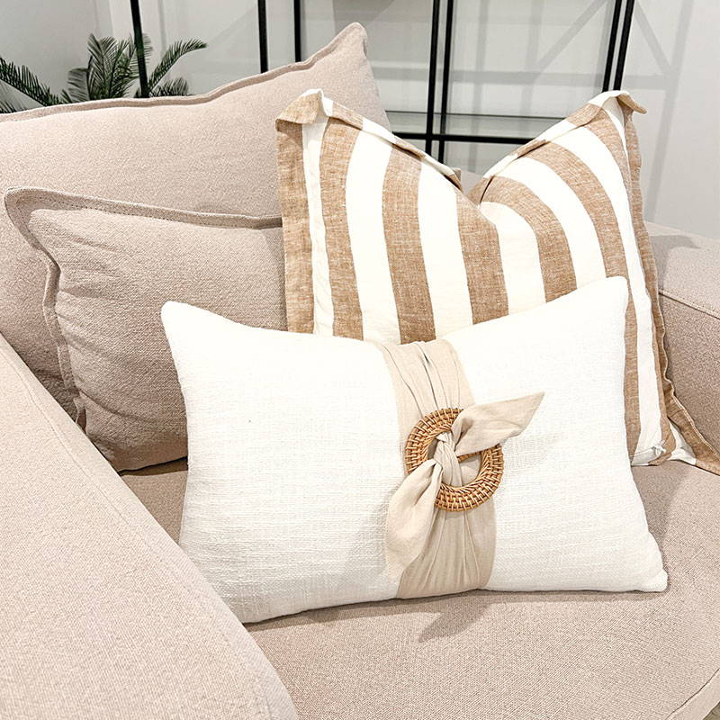 a versatile cushion that looks beautiful in this modern living room. Cream cushions that feature a round rattan buckles and natural sash