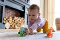 Baby putting a decoration on a birthday cake.