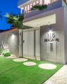 Modern facade lighting with soft wall washing highlighting textures and entry details