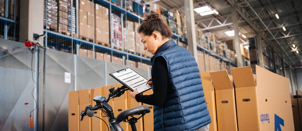woman looking at a bike and a clipboard
