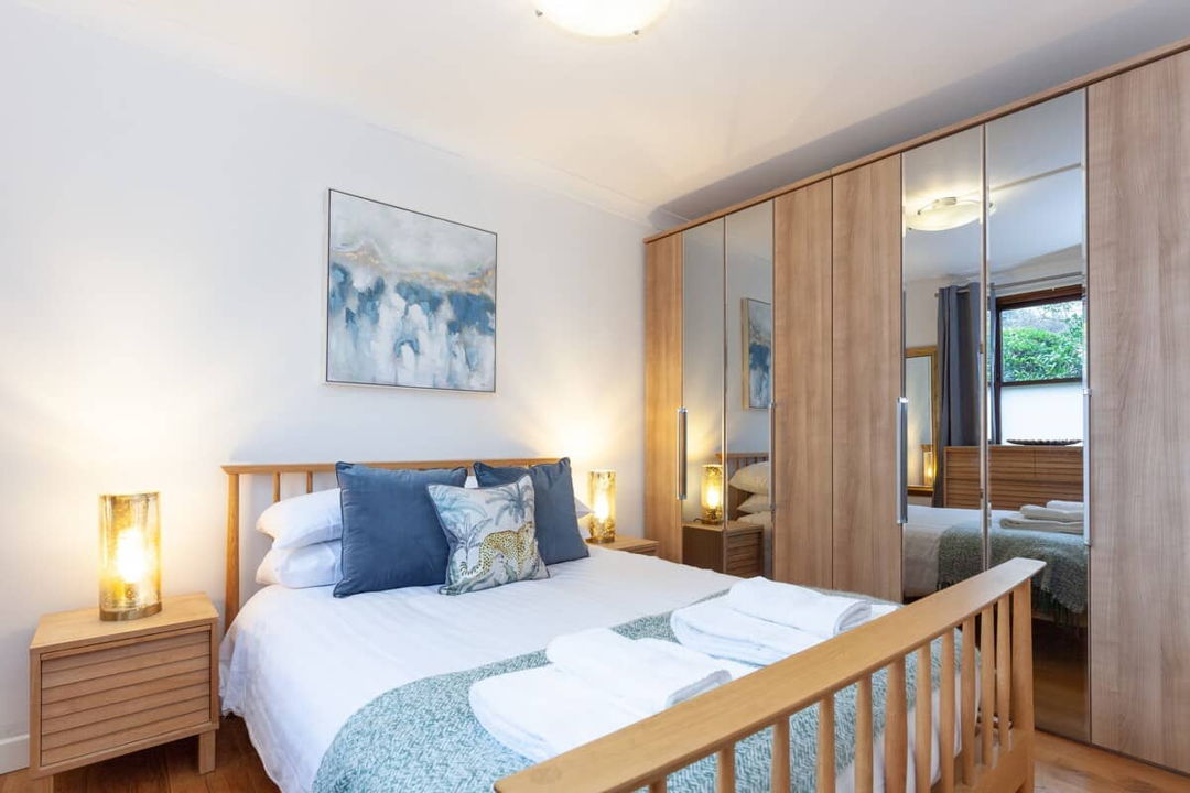Bedroom with large double bed and extra large clothing storage, with all soft furnishings