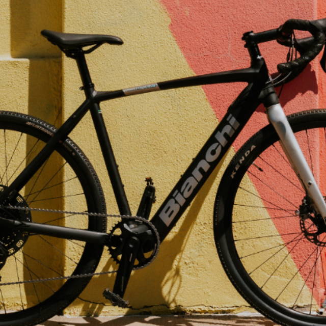 a bianchi electric road bike in front of a multicolored wall