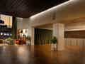 Geräumige Hotellobby mit Parkettboden, gemütlicher Sitzecke und großen Fenstern mit grünen Samtvorhängen.