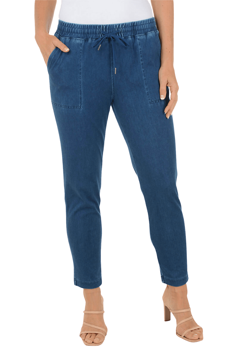 A woman wearing a blue denim drawstring pant and tan heeled sandals