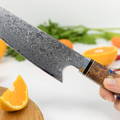 A hand carefully slicing an orange with a sharp knife, creating citrus wedges! 