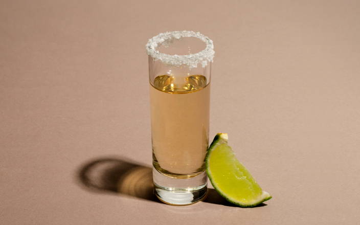Tequila shot glass with salt on the rim and a slice of lime (preview)