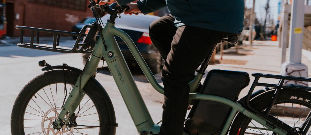 a man on a green Momentum PakYak E+ longtail electric cargo bike