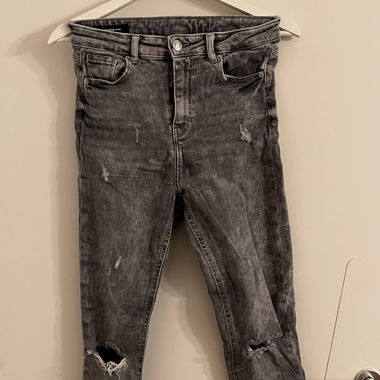 Graue zerissene Jeans