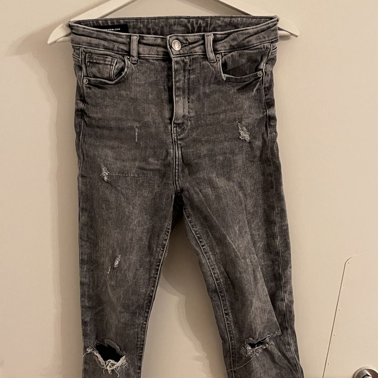 Graue zerissene Jeans