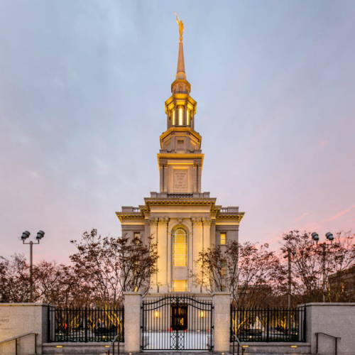 Photo of the Philadelphia Temple glowing against a blue and pink sky.