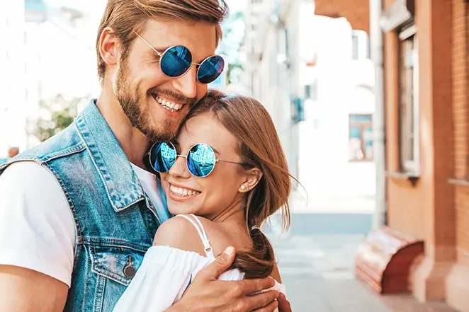 Belle fille souriante et son beau petit ami portant des lunettes de soleil.