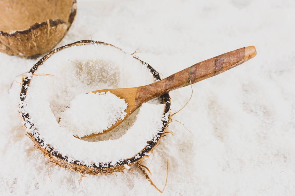 Coconut and coconut flakes with wooden spoon