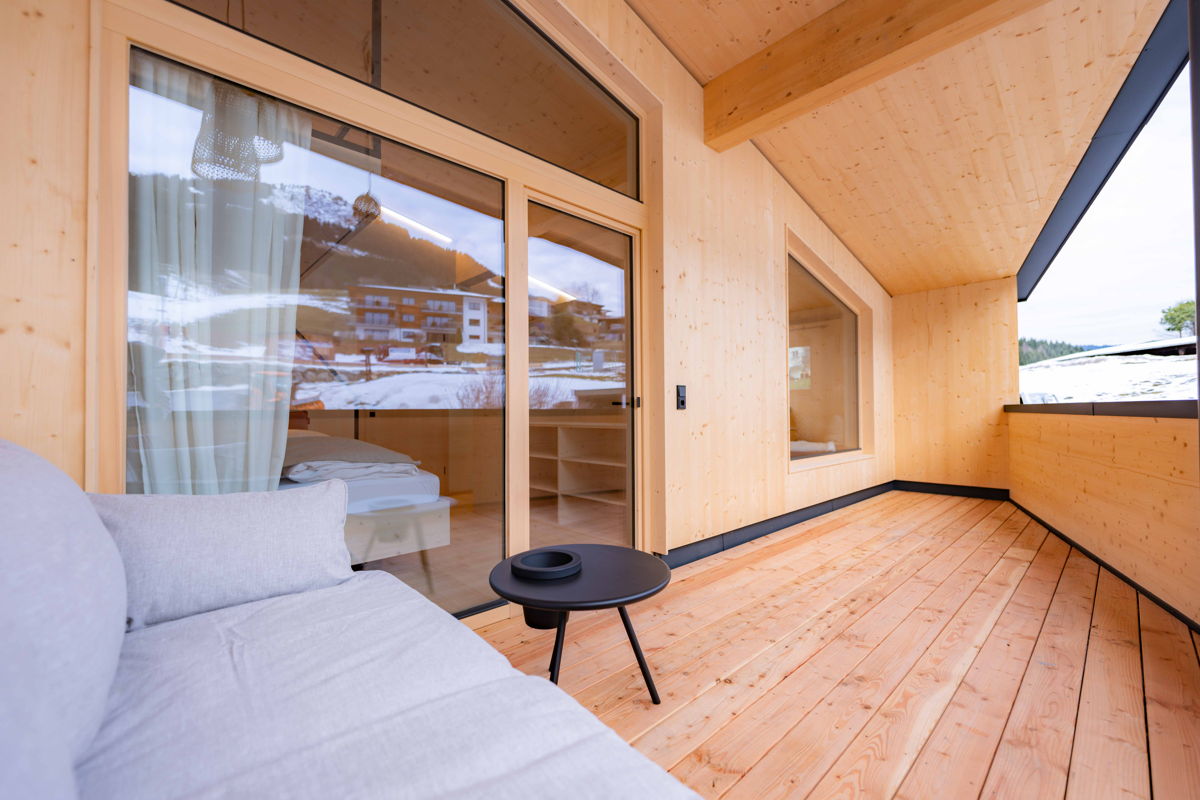 Balkon mit Sitzbereich und Blick auf die Berge im Zimmer Cozy Kabel in Mittelberg im Kleinwalsertal.